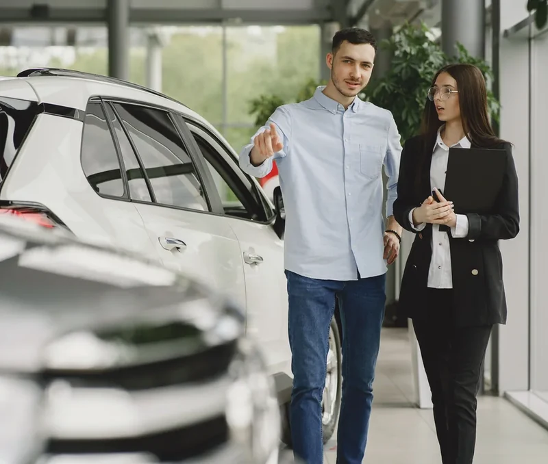 Customer speaking with a salesperson inside a car dealership